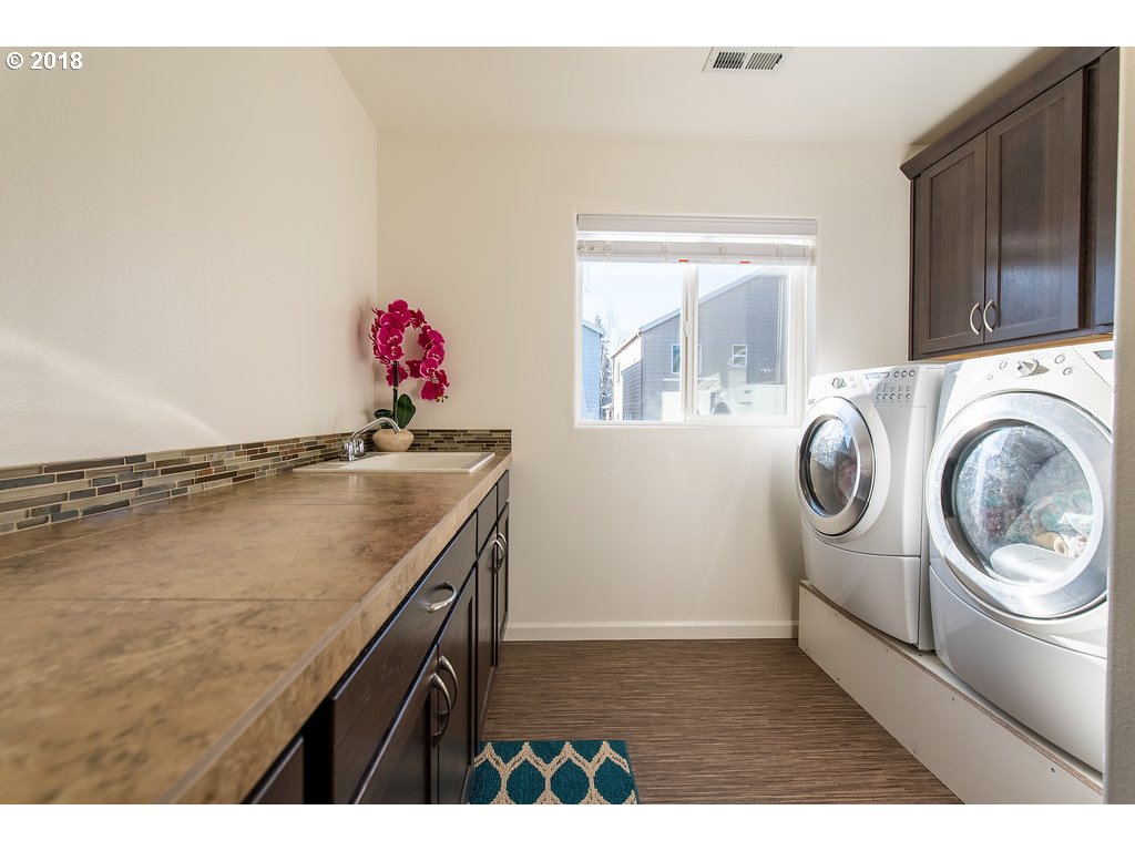 5047 Southwest 206th Place Beaverton, OR 97078 - Photo 11 of 28 a bathroom with a granite countertop sink and a washing machine