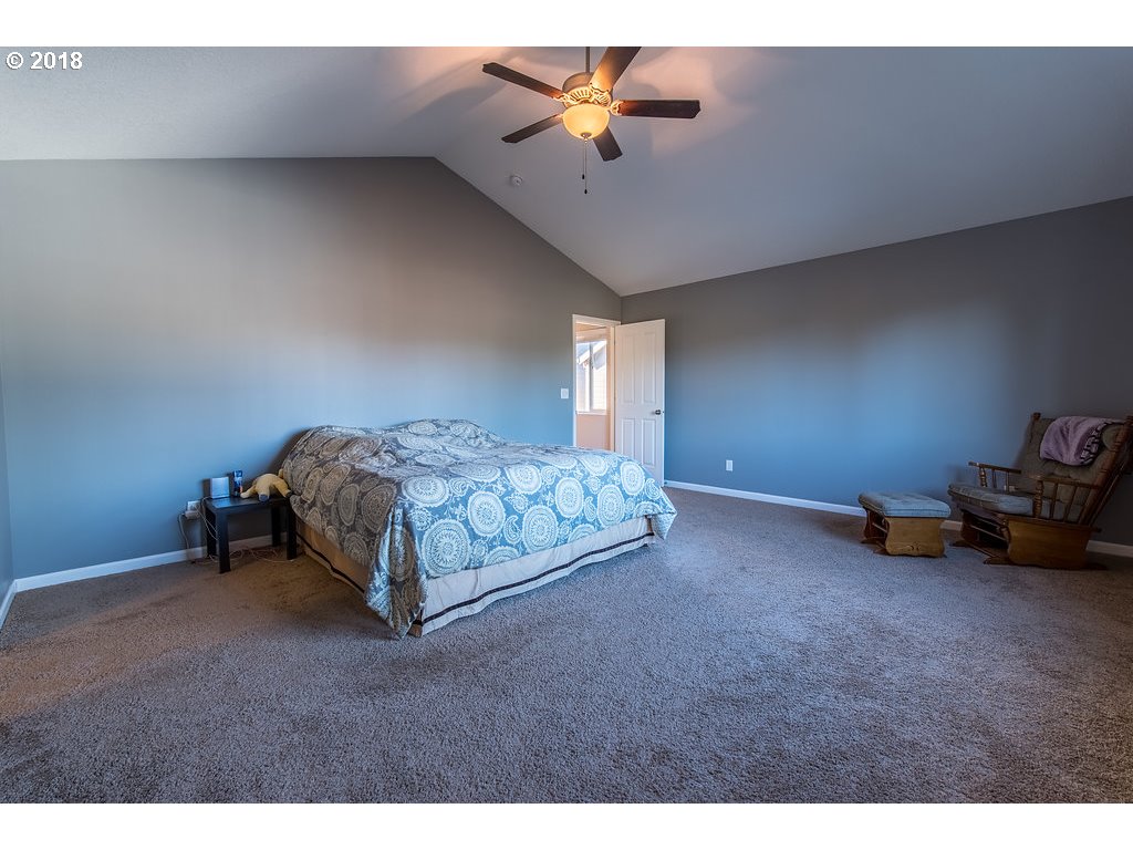 5047 Southwest 206th Place Beaverton, OR 97078 - Photo 13 of 28 a spacious bedroom with a bed and a chandelier