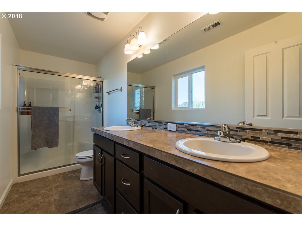 5047 Southwest 206th Place Beaverton, OR 97078 - Photo 14 of 28 a bathroom with a granite countertop sink a mirror and a shower