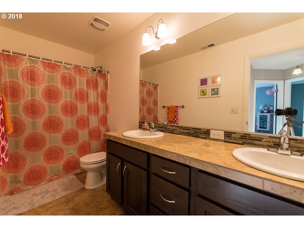 5047 Southwest 206th Place Beaverton, OR 97078 - Photo 19 of 28 a bathroom with a granite countertop sink a toilet and a mirror