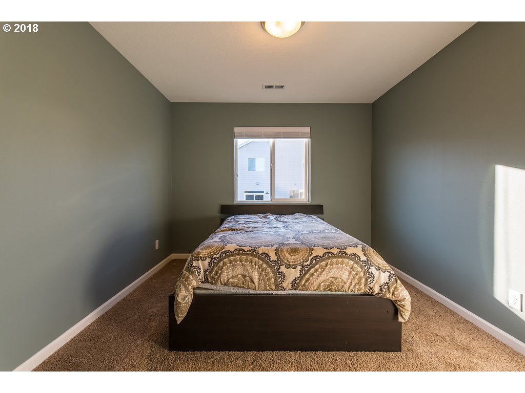 5047 Southwest 206th Place Beaverton, OR 97078 - Photo 21 of 28 a bed sitting in a bedroom next to a window