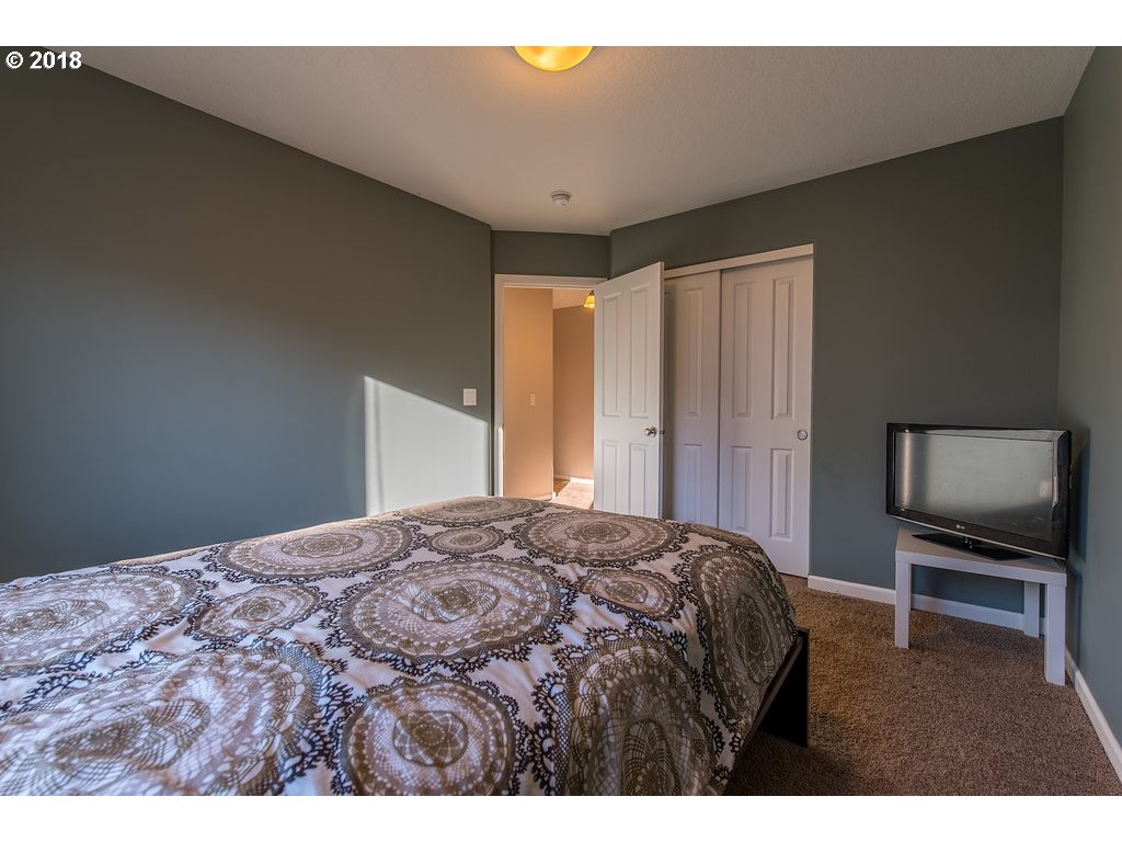 5047 Southwest 206th Place Beaverton, OR 97078 - Photo 23 of 28 a bedroom with a bed and a flat screen tv