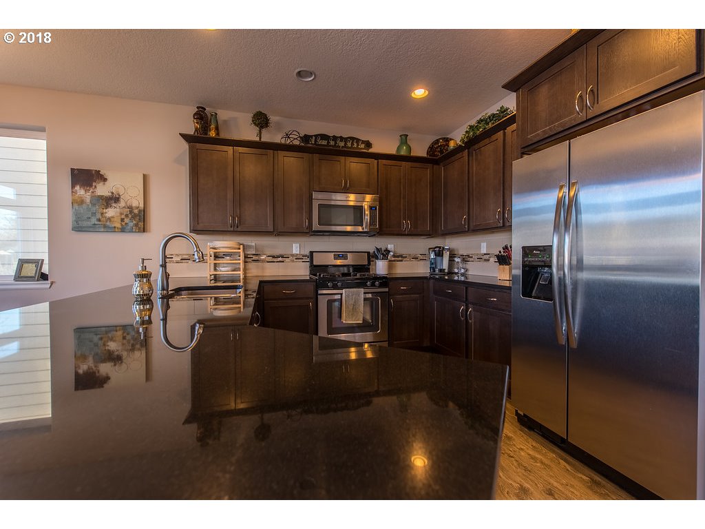 5047 Southwest 206th Place Beaverton, OR 97078 - Photo 9 of 28 a kitchen with kitchen island a counter top space cabinets and stainless steel appliances