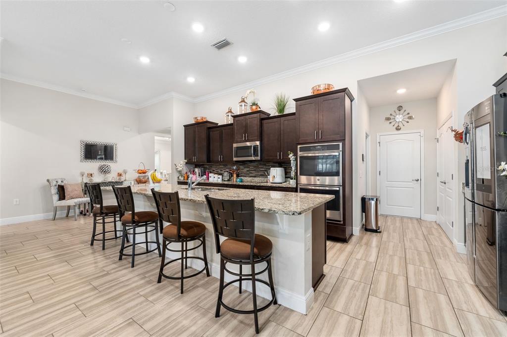 5615 Southwest 215th Terrace Newberry, FL 32669 - Photo 14 of 45 a kitchen with stainless steel appliances a dining table chairs microwave and sink