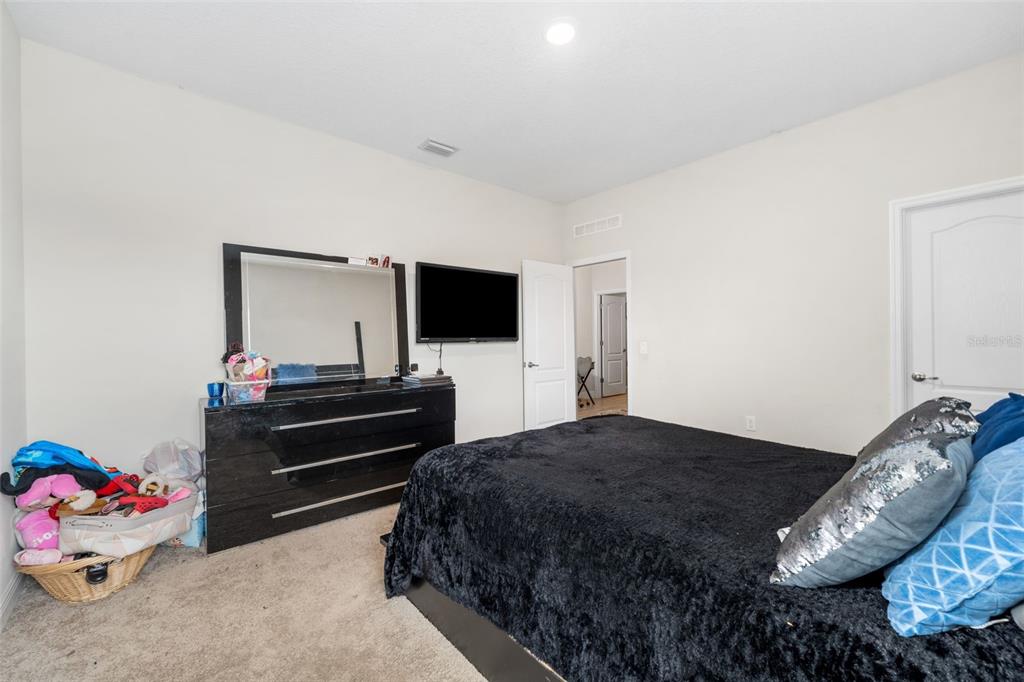 5615 Southwest 215th Terrace Newberry, FL 32669 - Photo 28 of 45 a bedroom with a bed and a flat screen tv