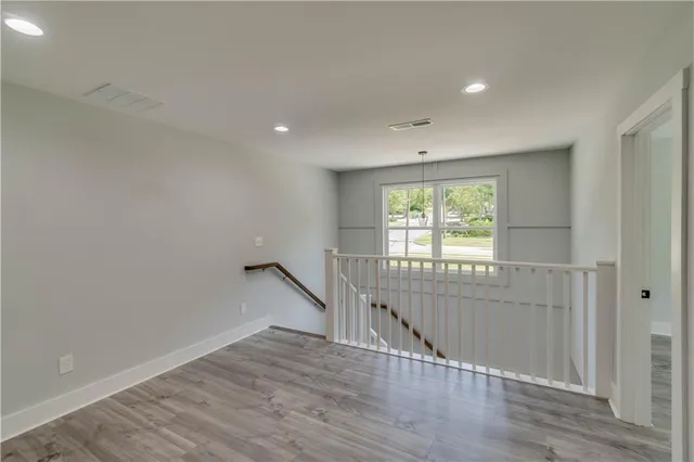 a view of empty room with wooden floor