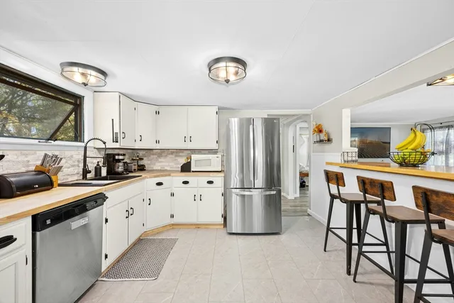 a kitchen with stainless steel appliances a refrigerator a stove a sink and a refrigerator