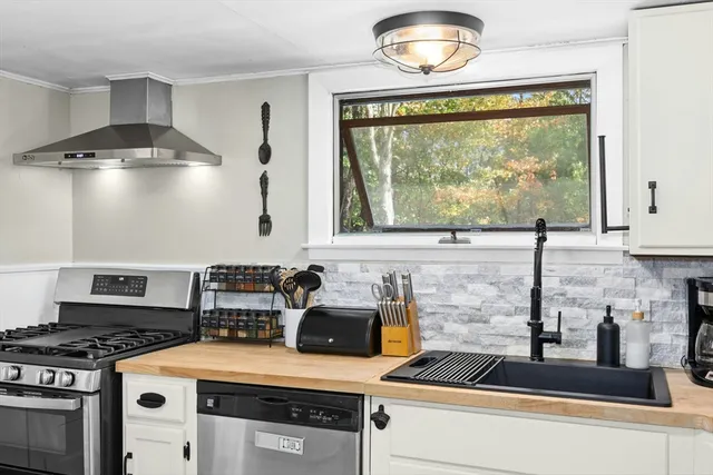 a kitchen with a stove a sink and a window