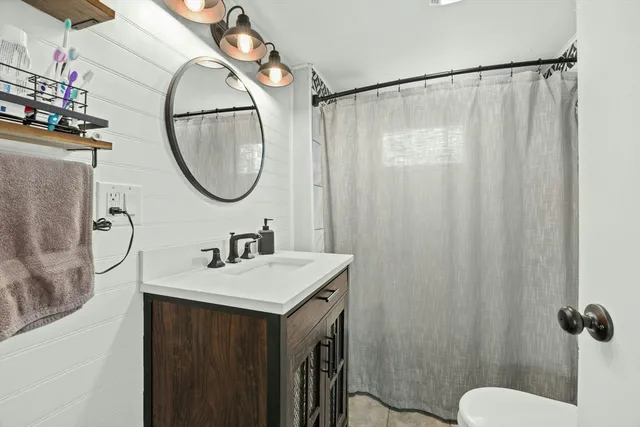 a bathroom with a sink vanity mirror and tub