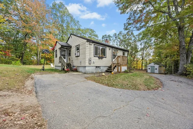 a view of a house with a yard and large tree