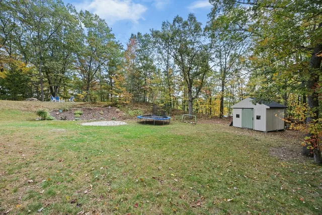 a front view of a house with a yard and trees