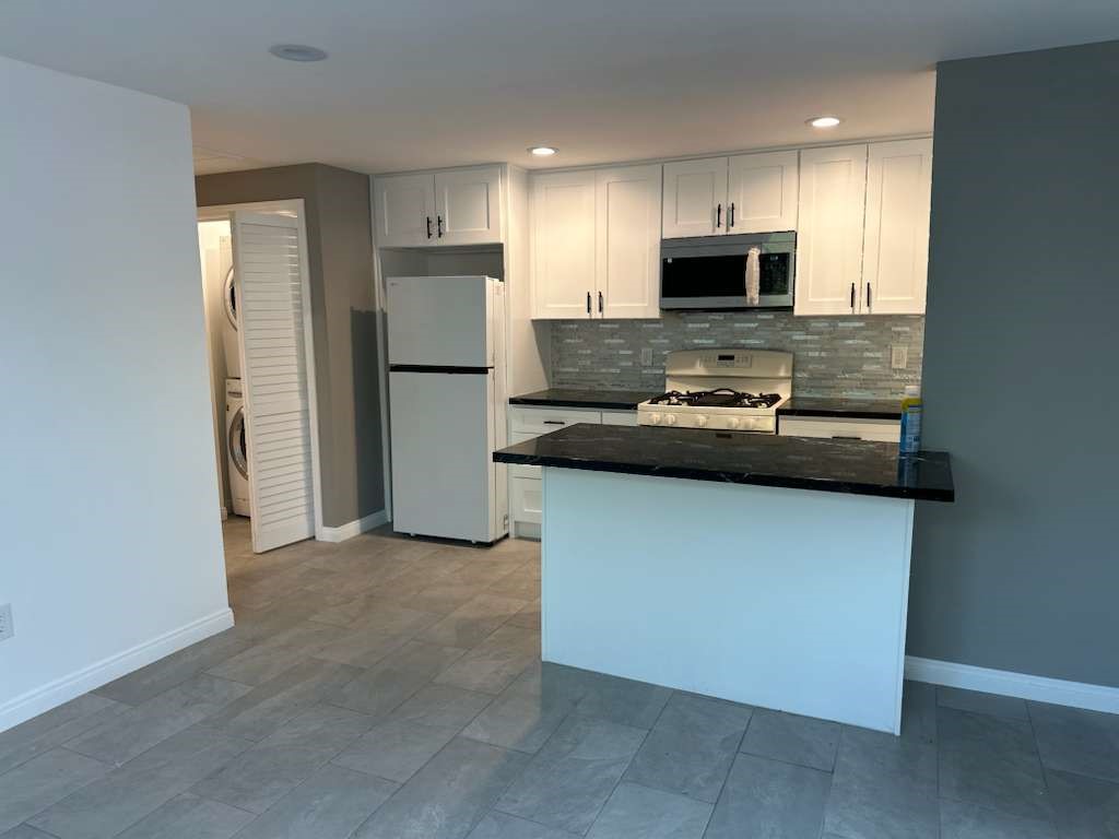 6527 Tampa Reseda, CA 91335 - Photo 3 of 10 a kitchen with kitchen island a refrigerator sink and microwave