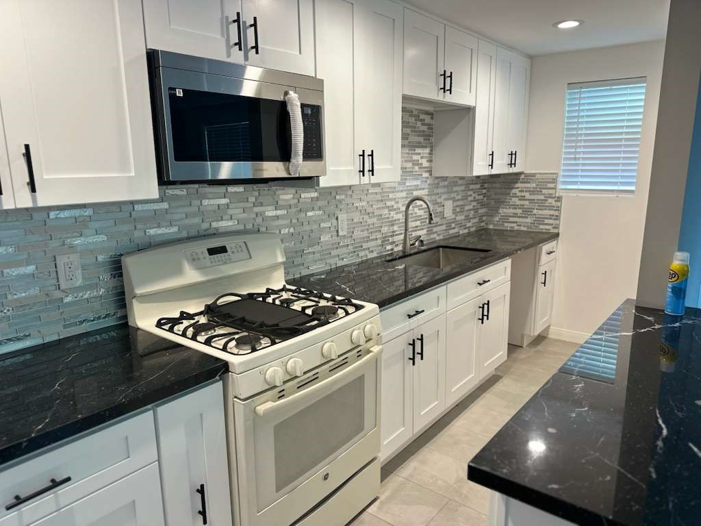 6527 Tampa Reseda, CA 91335 - Photo 8 of 10 a kitchen with stainless steel appliances granite countertop a sink stove and microwave