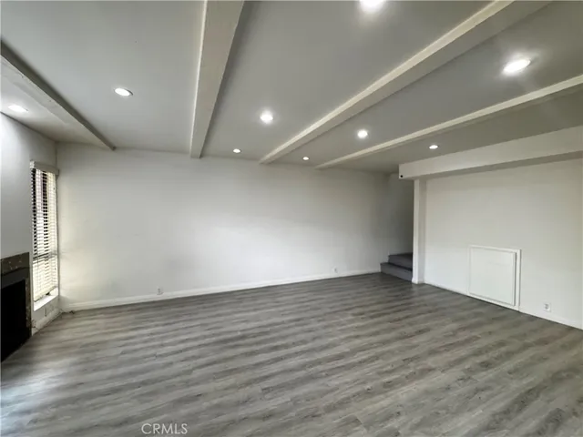 an empty room with wooden floor and a fireplace