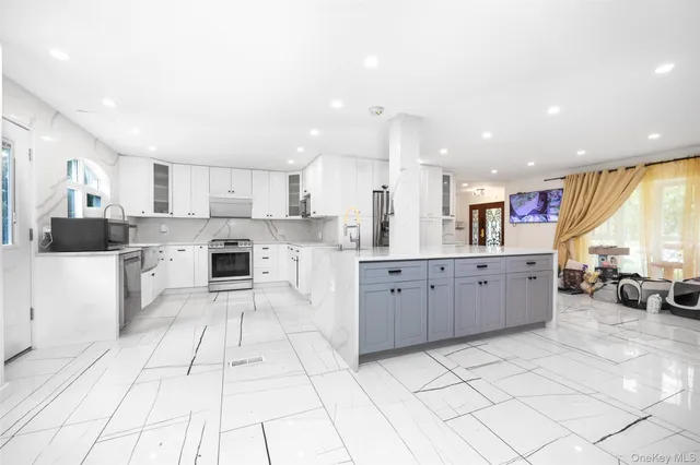 a large white kitchen with cabinets