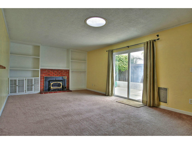 185 College Road Watsonville, CA 95076 - Photo 4 of 13 a view of an empty room with a fireplace and a window