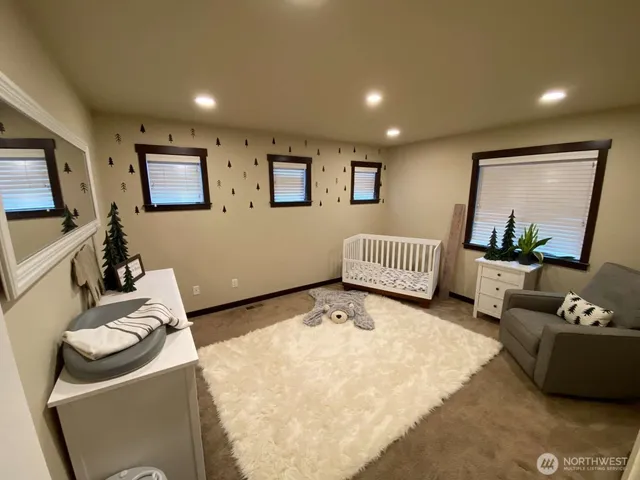 a bedroom with furniture and a large window