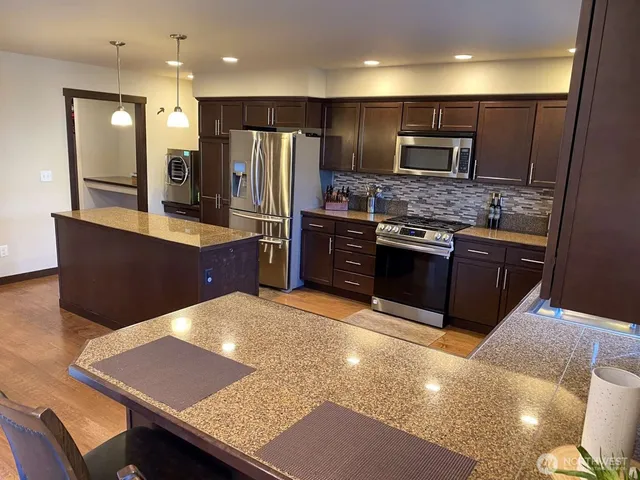 a kitchen with stainless steel appliances granite countertop a sink stove and refrigerator