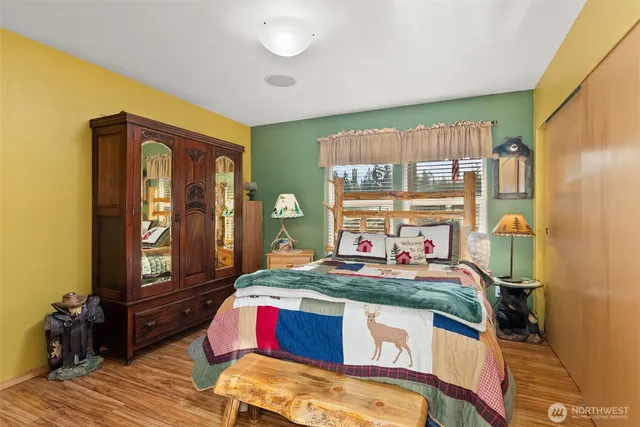 a bedroom with bed and wooden floor