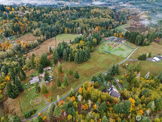 an aerial view of residential houses with outdoor space and trees