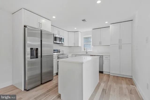 a kitchen with a refrigerator sink and cabinets