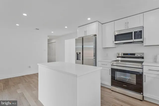 a kitchen with stainless steel appliances a stove microwave and refrigerator
