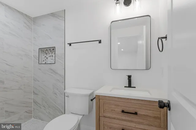 a bathroom with a toilet sink vanity and mirror