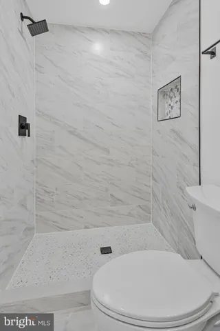 a bathroom with a toilet and a shower