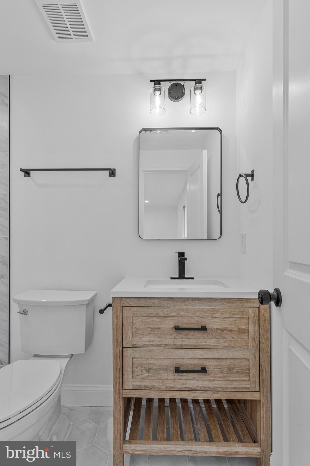 3365 Arundel On The Bay Road Annapolis, MD 21403 - Photo 31 of 48 a bathroom with a toilet a sink and mirror