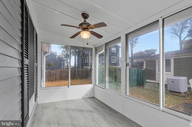 a view of a big room with wooden floor and a chandelier fan