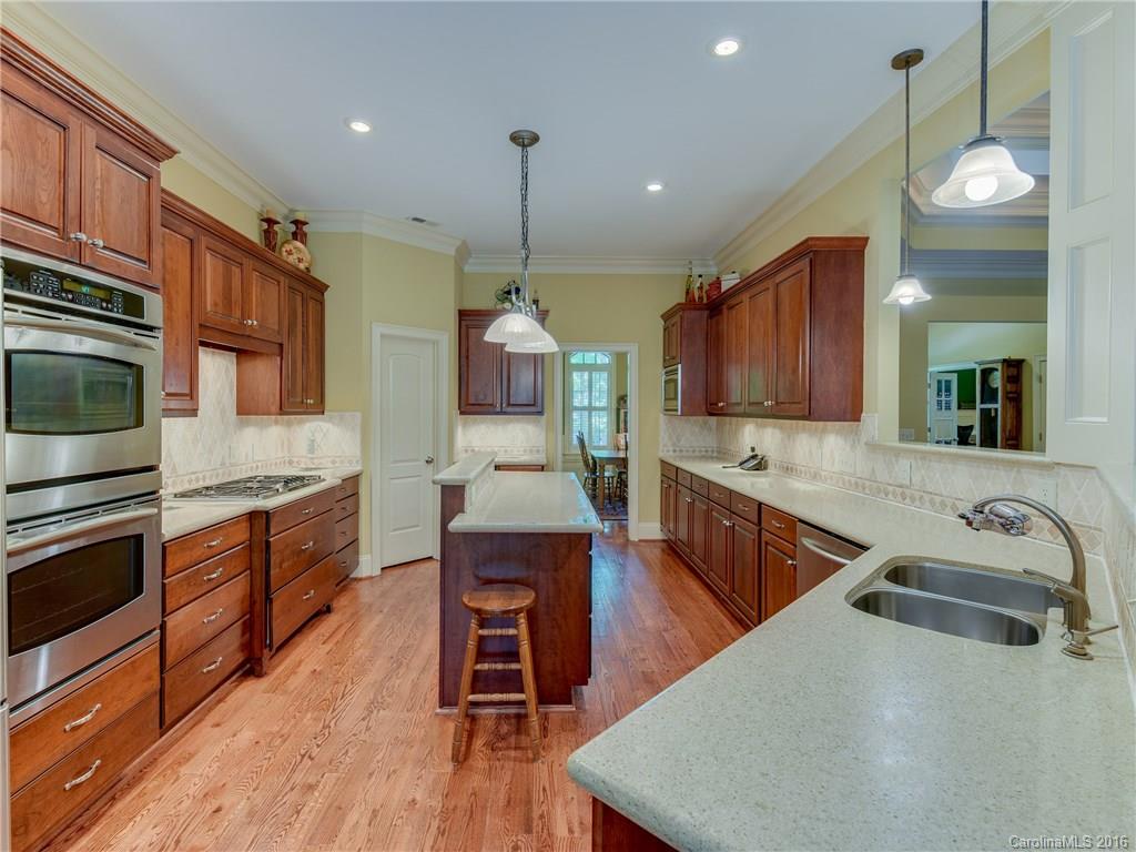 6706 Fox Ridge Circle Davidson, NC 28036 - Photo 7 of 24 a kitchen with stainless steel appliances granite countertop wooden cabinets a stove a sink and a center island