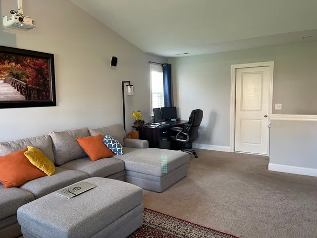 a living room with furniture ceiling fan and a window