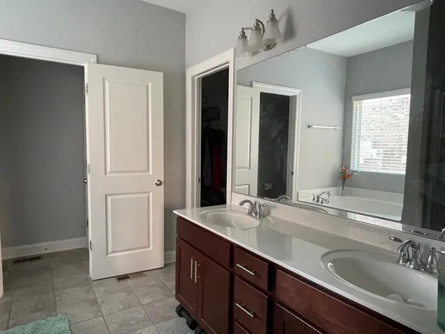 a bathroom with a double vanity sink and a mirror
