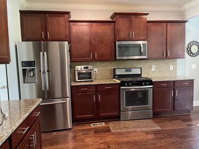 a kitchen with stainless steel appliances granite countertop a refrigerator microwave and sink