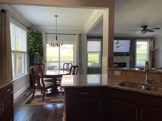 a kitchen with granite countertop a sink dining table and chairs
