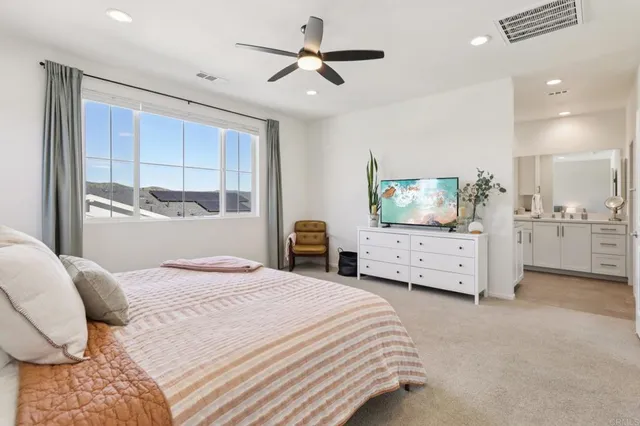 a bedroom with a bed and a flat tv screen on the dresser