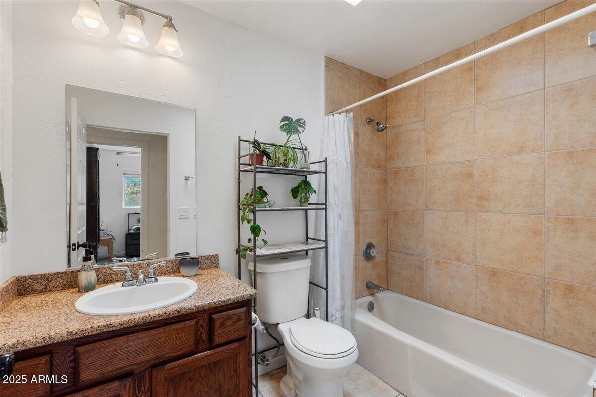 2527 Rio Verde Drive Cottonwood, AZ 86326 - Photo 15 of 43 a bathroom with a granite countertop sink toilet a mirror and shower
