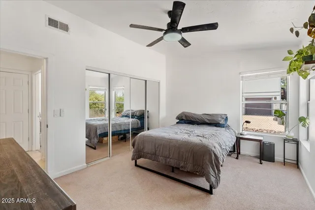a bedroom with a bed a chandelier and a window