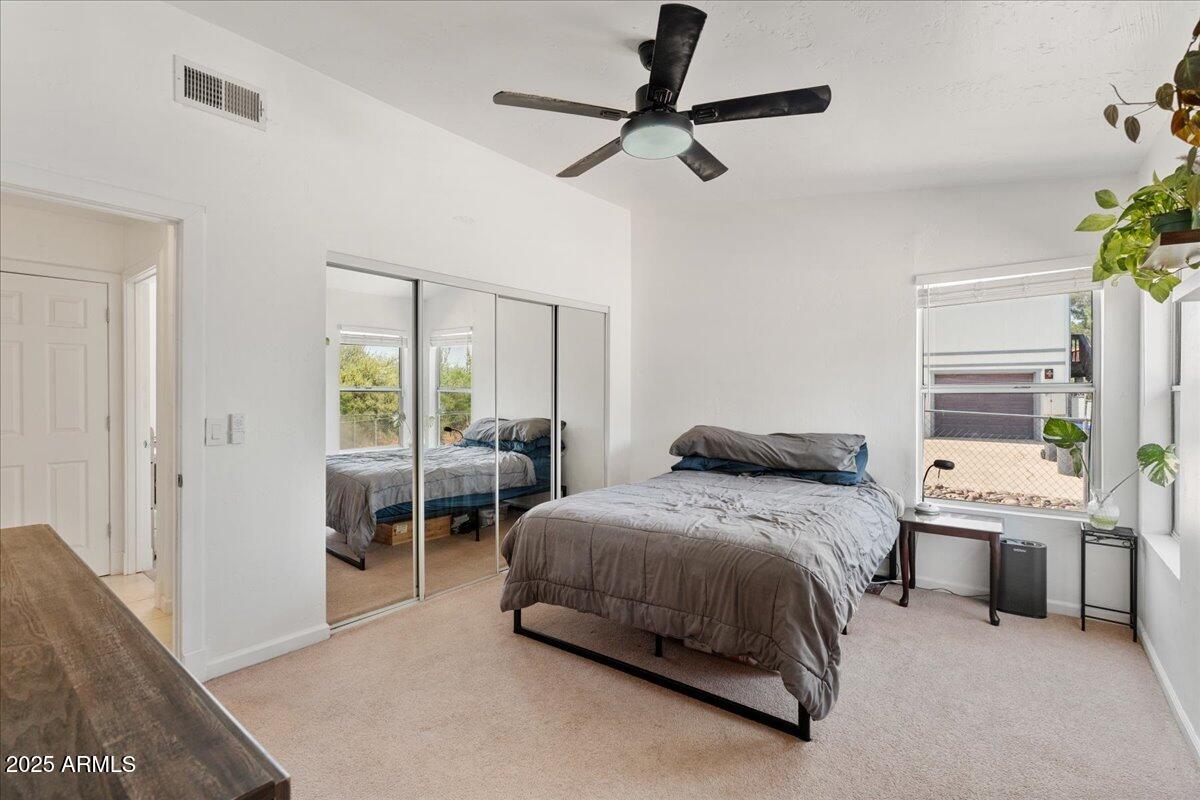 2527 Rio Verde Drive Cottonwood, AZ 86326 - Photo 19 of 43 a bedroom with a bed a chandelier and a window