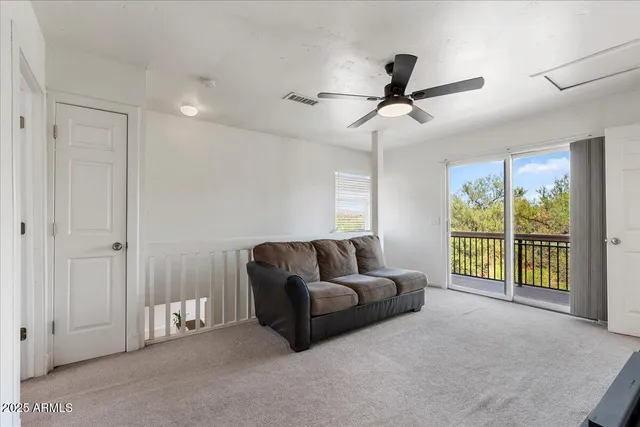 a living room with furniture and a ceiling fan