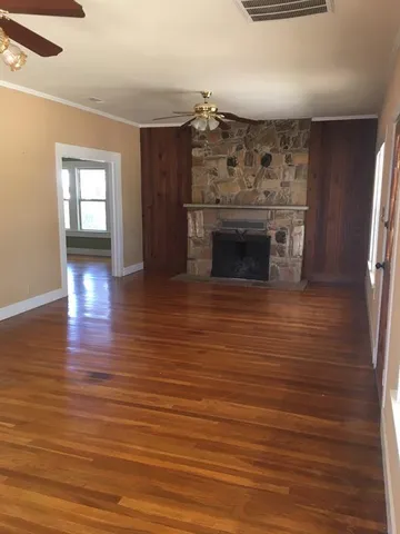 wooden floor fireplace and windows in an empty room