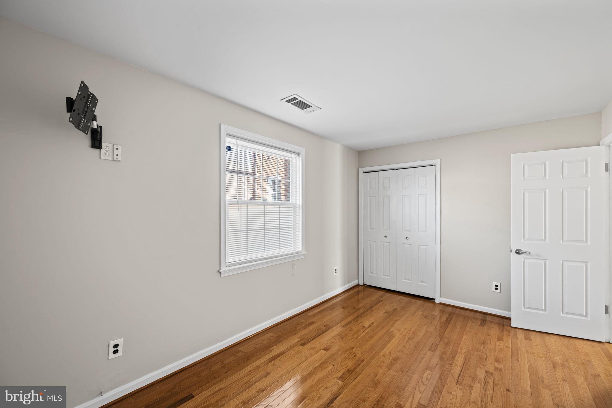 2001 Fort Davis Street Southeast, Unit 102 Washington, DC 20020 - Photo 17 of 30 an empty room with wooden floor and windows
