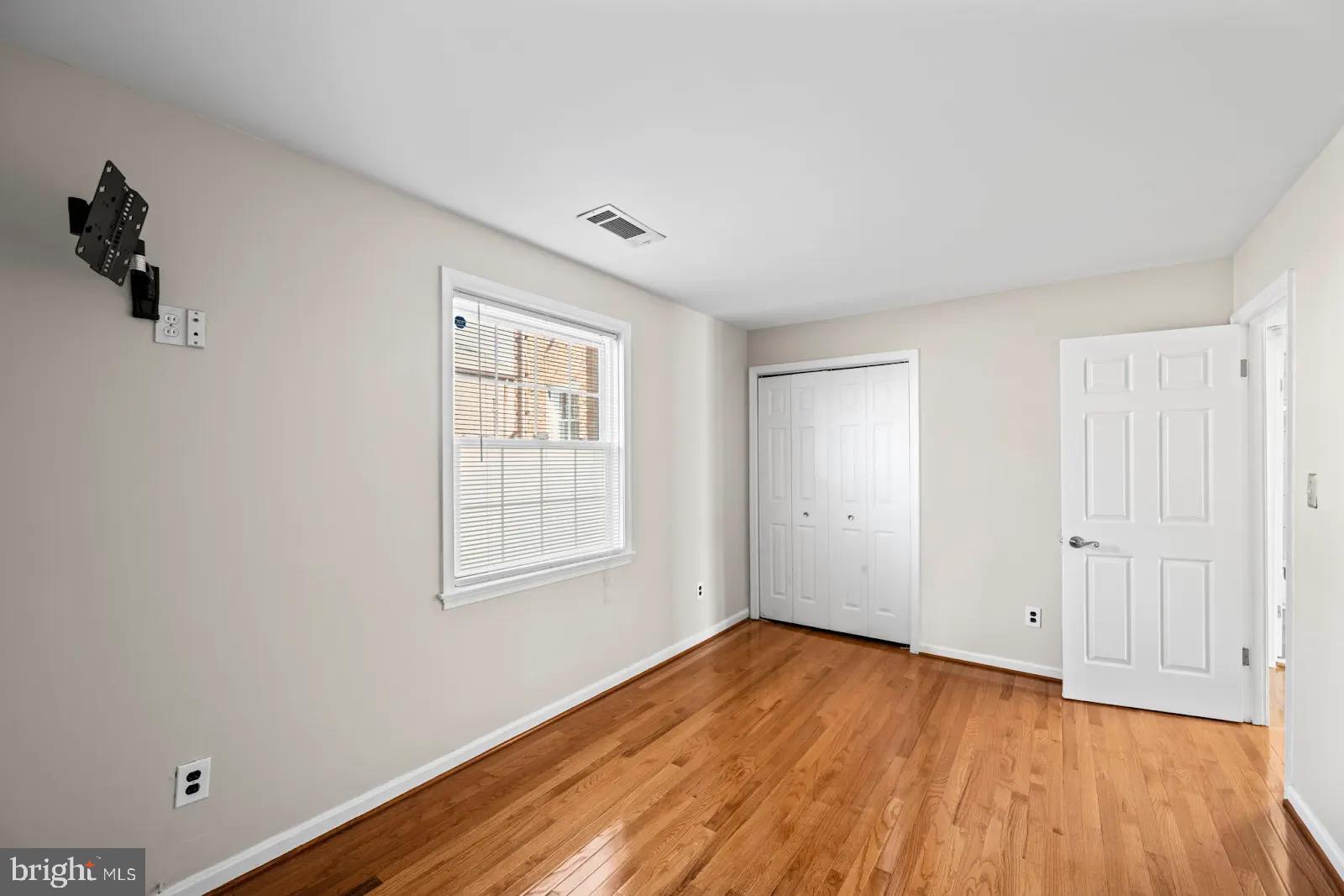 2001 Fort Davis Street Southeast, Unit 102 Washington, DC 20020 - Photo 18 of 30 an empty room with wooden floor and windows
