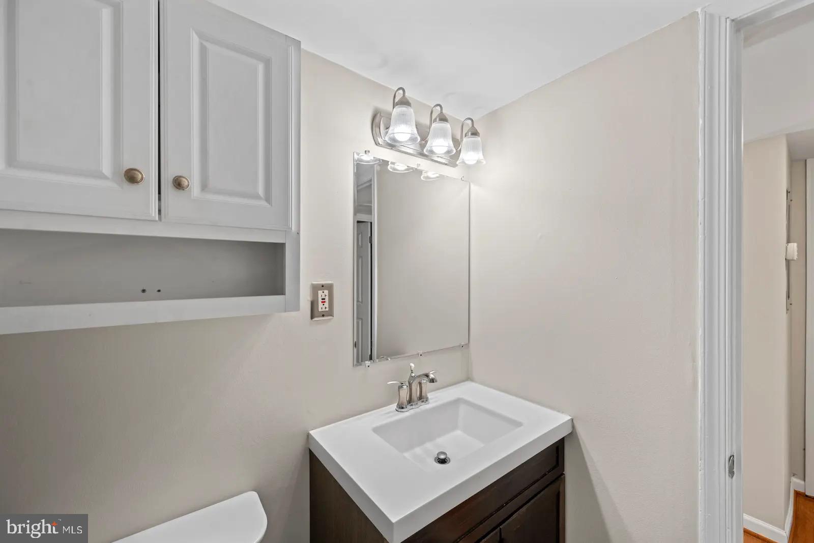 2001 Fort Davis Street Southeast, Unit 102 Washington, DC 20020 - Photo 21 of 30 a bathroom with a sink a toilet and a mirror