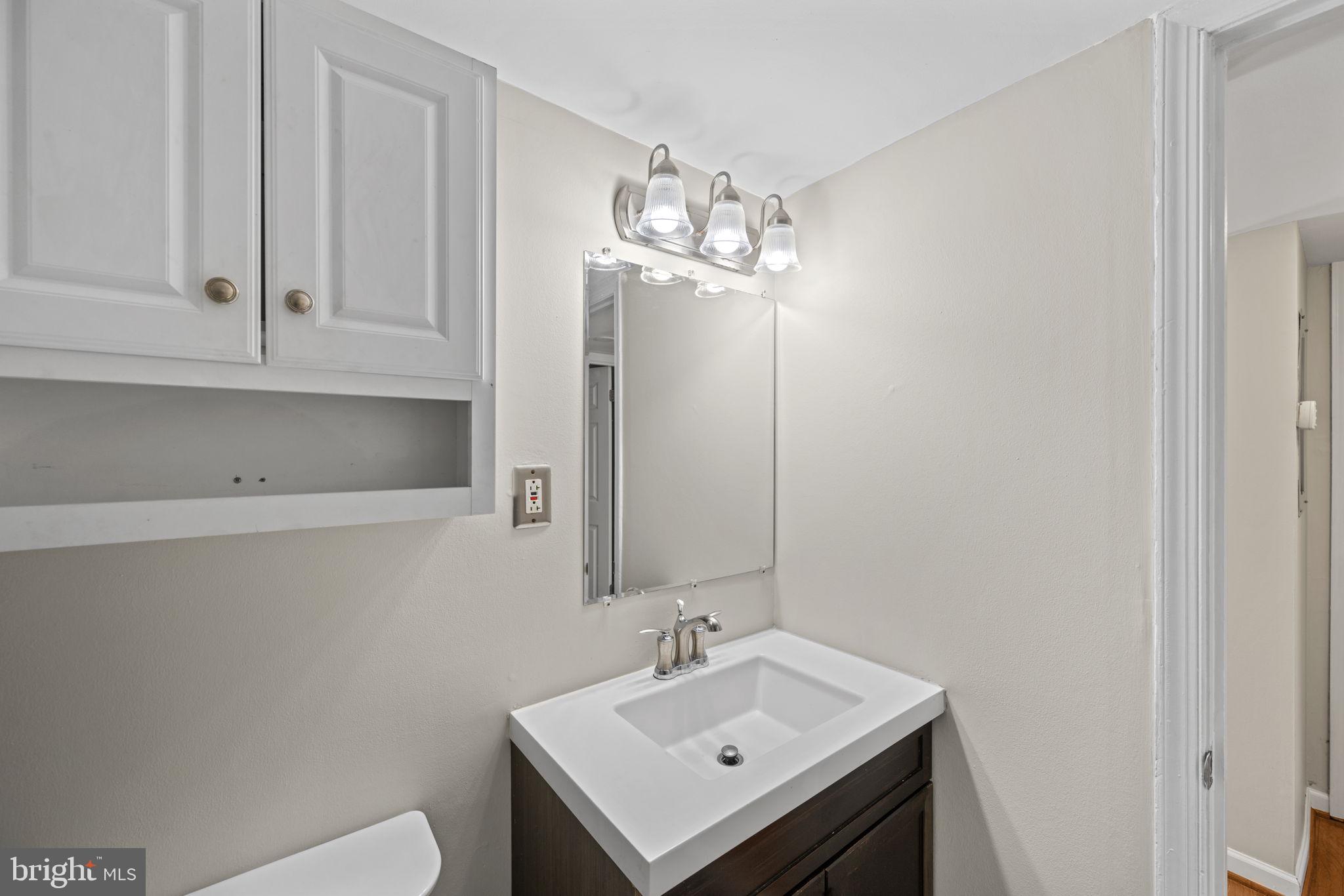 2001 Fort Davis Street Southeast, Unit 102 Washington, DC 20020 - Photo 22 of 30 a bathroom with a sink a toilet and a mirror