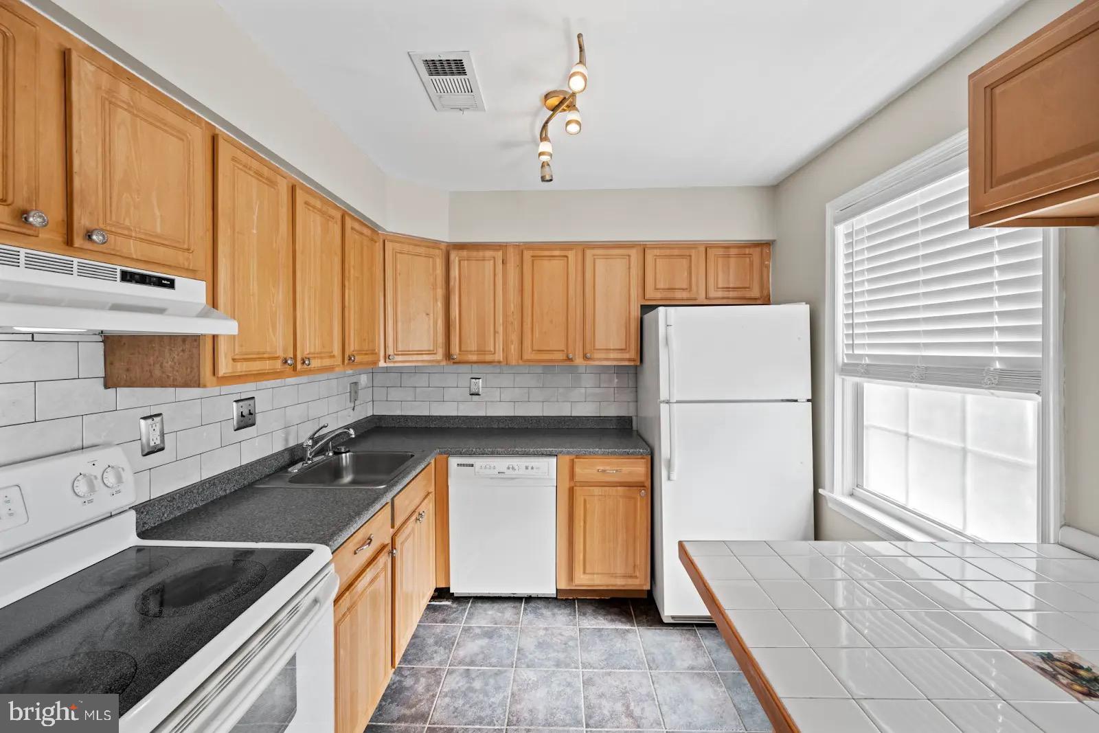 2001 Fort Davis Street Southeast, Unit 102 Washington, DC 20020 - Photo 5 of 30 a kitchen with a sink stove and refrigerator