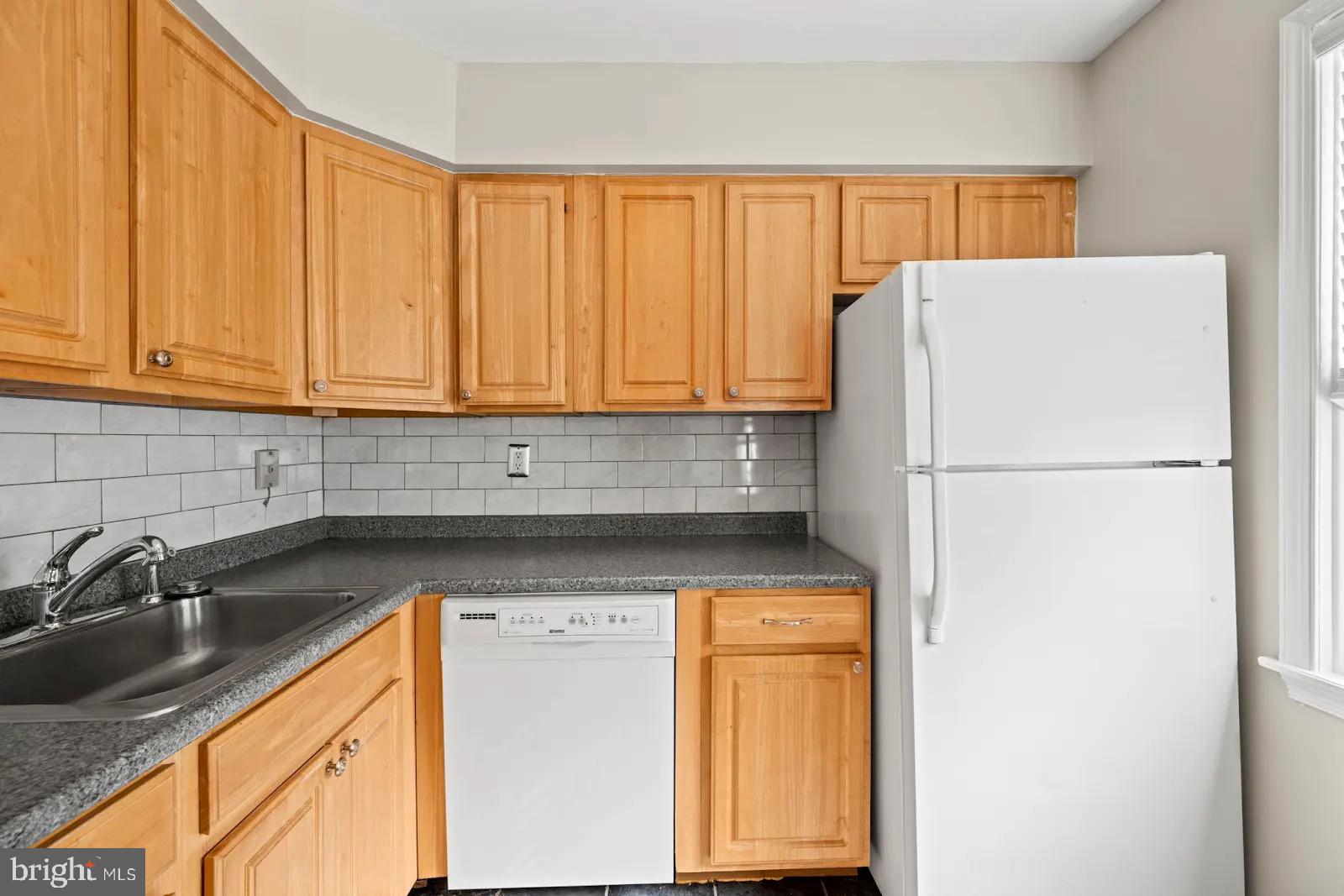 2001 Fort Davis Street Southeast, Unit 102 Washington, DC 20020 - Photo 7 of 30 a kitchen with a refrigerator a sink and cabinets