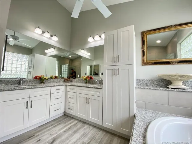 a bathroom with a granite countertop sink a toilet a mirror and vanity