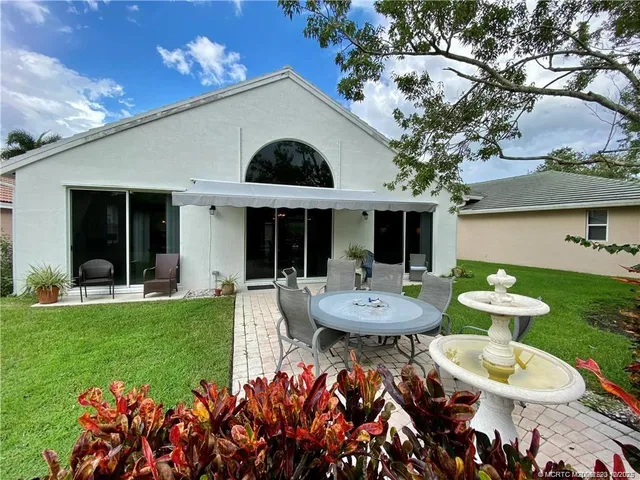 a view of a house with backyard sitting area and garden