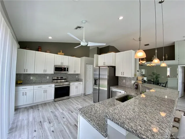 a kitchen with stainless steel appliances granite countertop a sink refrigerator and microwave